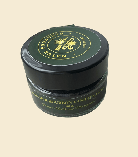 Vanillekaviar und geöffnete Bourbon-Vanilleschote auf weißem Teller