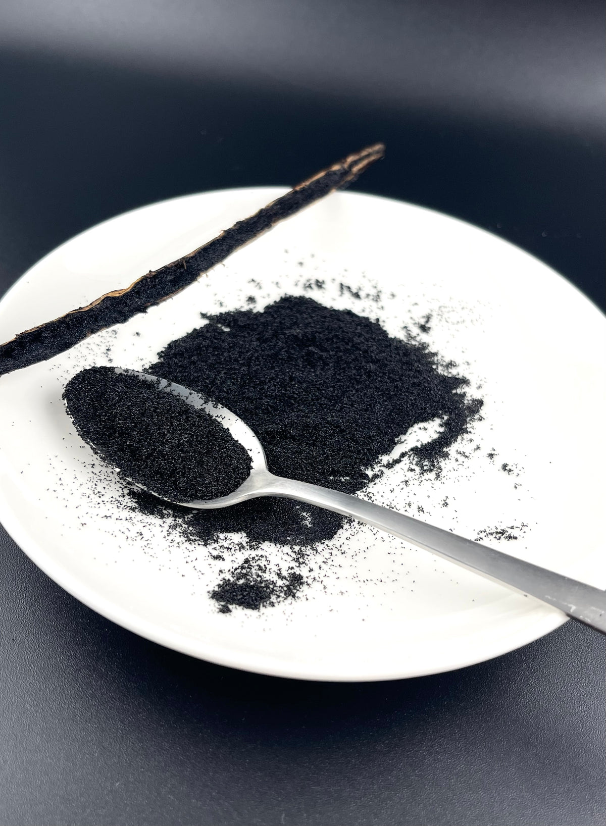 Getrocknete Vanillesamen neben einer aufgeschnittenen Bourbon-Vanilleschote