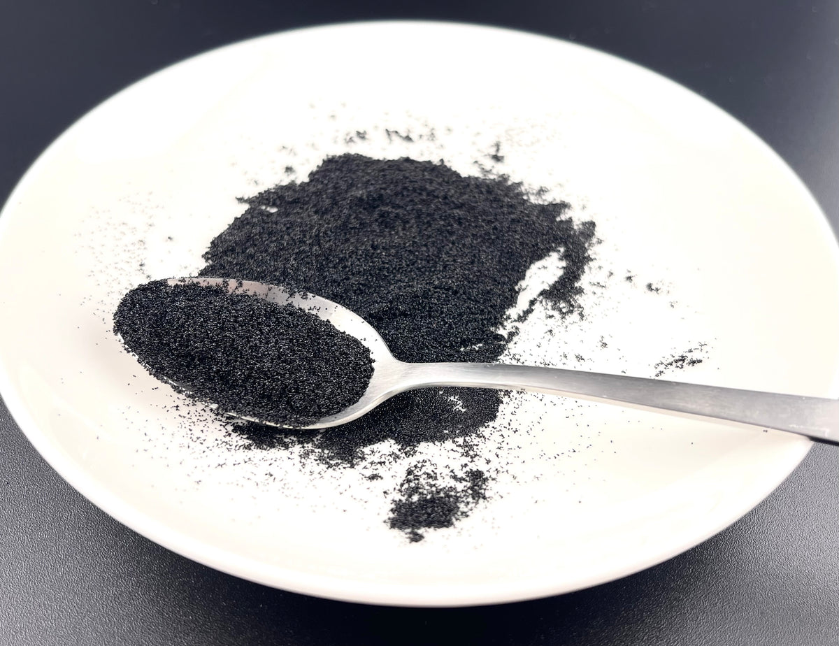 Löffel mit getrockneten Bourbon-Vanillesamen auf einem weißen Teller